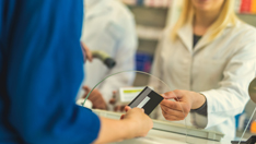 Customer using credit card to pay the bill for medications in a drugstore, pharmacy.
